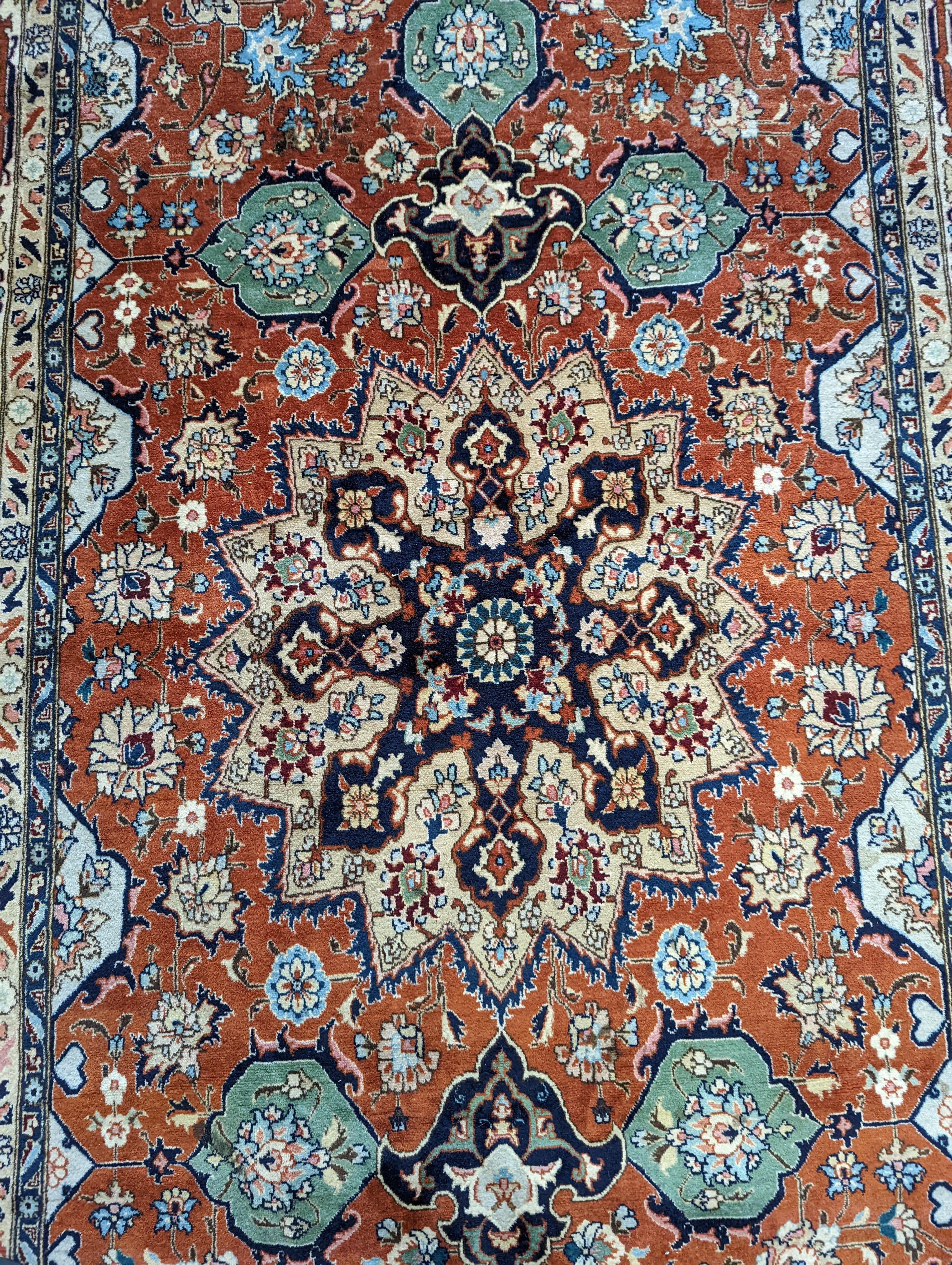 A Tabriz brick red ground rug, 230 x 138cm